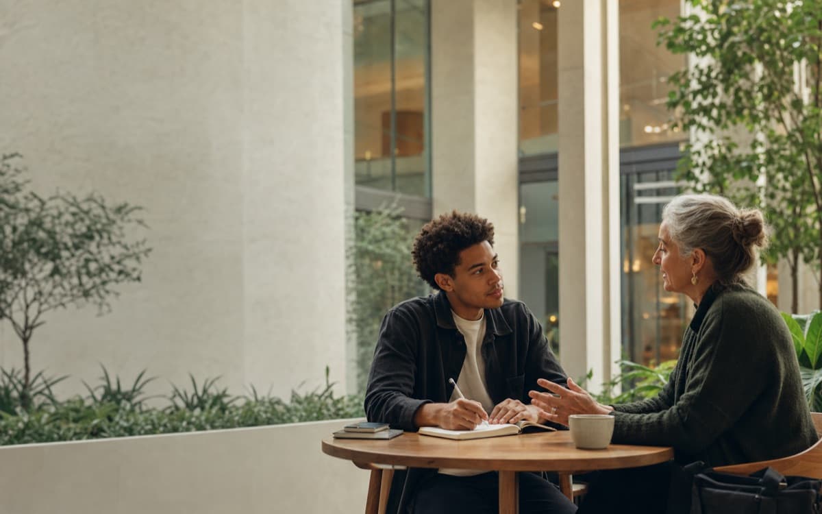 A member and advisor in conversation over coffee
